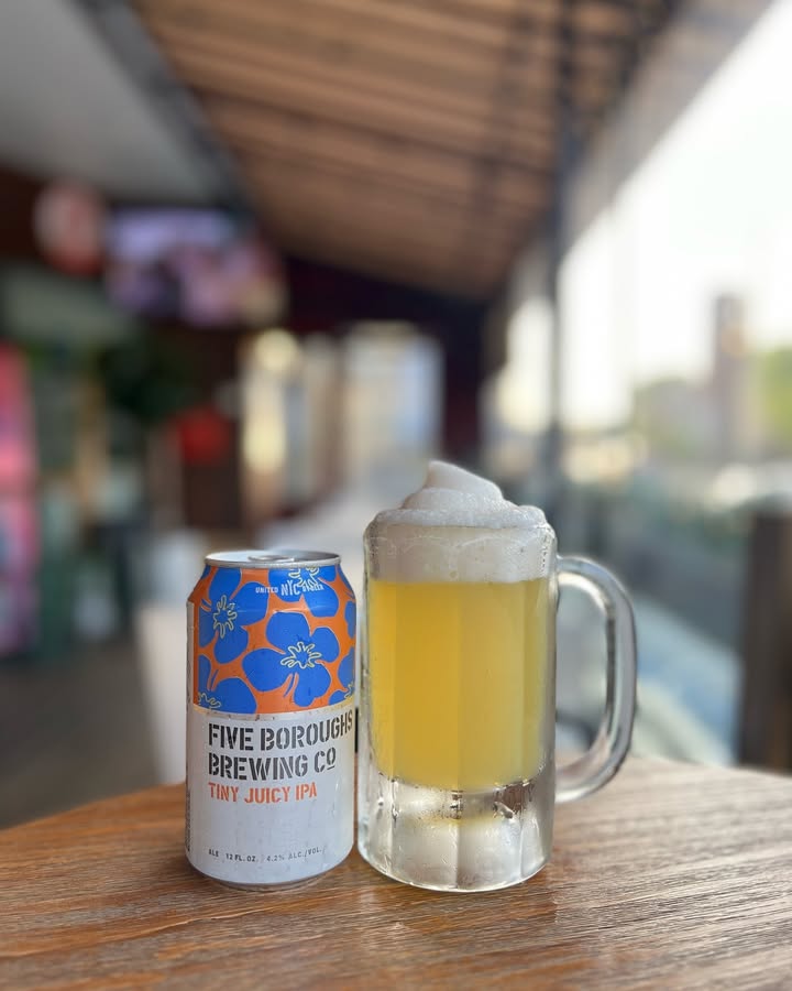 A can of Five Boroughs Tiny Juicy IPA next to a frosty mug of beer