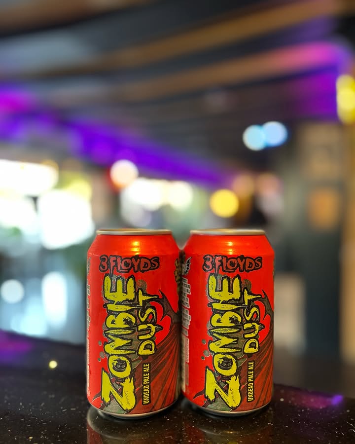 Two cans of 3 Floyds Zombie Dust pale ale on the bar