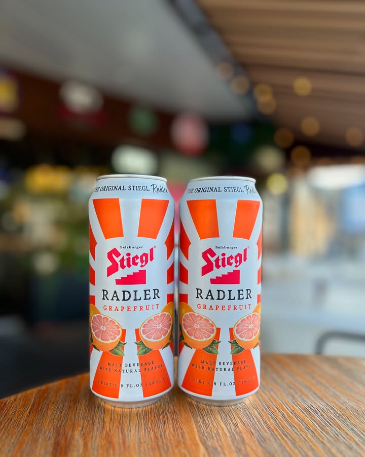 Two cans of Stiegl Grapefruit Radler on a wooden table