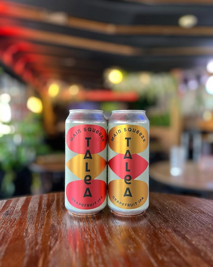 Two cans of Talea beer on a wooden table