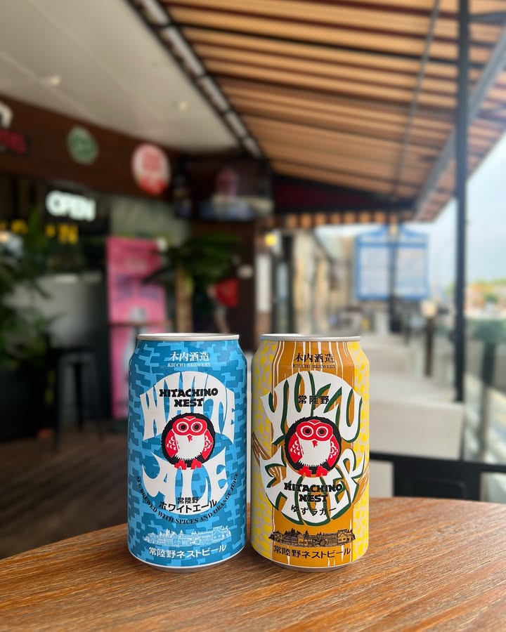 Cans of Hitachino Nest White Ale and Yuzu Lager on a wooden table