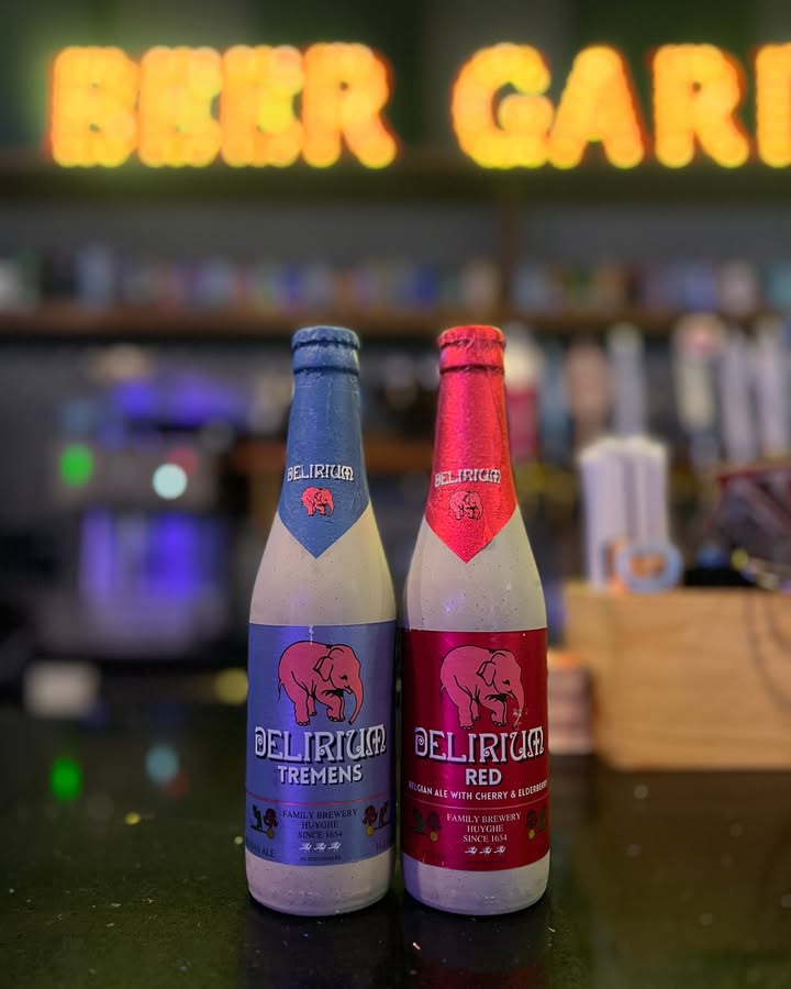 Bottles of Delirium Tremens and Delirium Red under the lit Beer Garden sign
